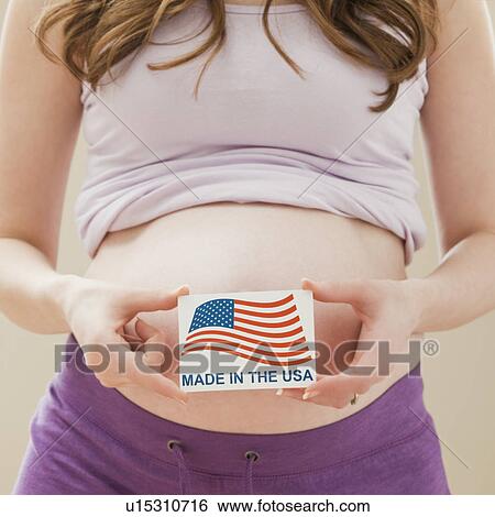 Stock Photograph - Young pregnant woman holding Made in the USA Sign. Fotosearch