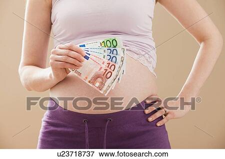 Young pregnant woman holding money roll of Euros View Large Photo Image Stock Photo - Young pregnant woman holding money roll of Euros. Fotosearch