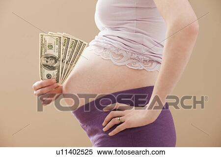 Young pregnant woman holding money roll of Dollars View Large Photo Image Stock Photography - Young pregnant woman holding money roll of Dollars. Fotosearch