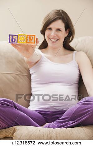 Stock Image - Young pregnant woman holding plastic letters reading: 'boy'. Fotosearch