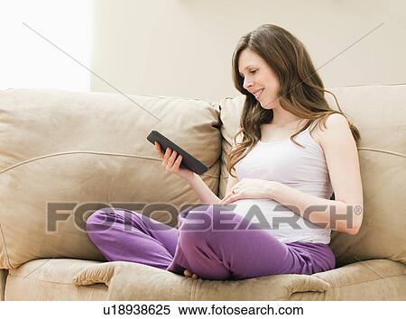Stock Photography - Young pregnant woman looking at CT image of unborn baby. Fotosearch