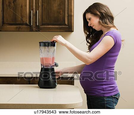 Young pregnant woman using juice extractor View Large Photo Image Stock Image - Young pregnant woman using juice extractor. Fotosearch