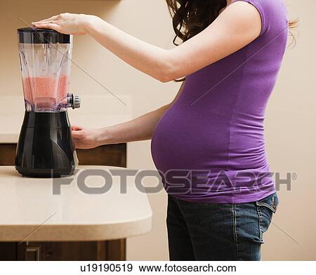 Young pregnant woman using juice extractor View Large Photo Image Stock Photo - Young pregnant woman using juice extractor. Fotosearch