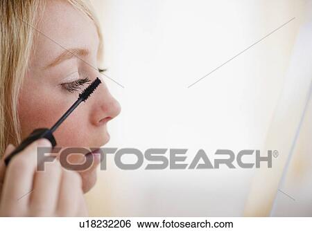 Young woman applying mascara View Large Photo Image Stock Photograph - Young woman applying mascara. Fotosearch