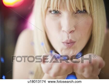 Young woman blowing confetti View Large Photo Image Picture - Young woman blowing confetti. Fotosearch