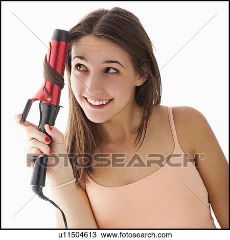 Young woman curling hair View Large Photo Image Stock Image - Young woman curling hair. Fotosearch