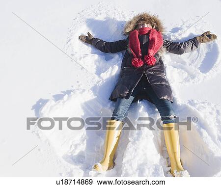 Young woman doing snow angel View Large Photo Image Stock Photo - Young woman doing snow angel. Fotosearch