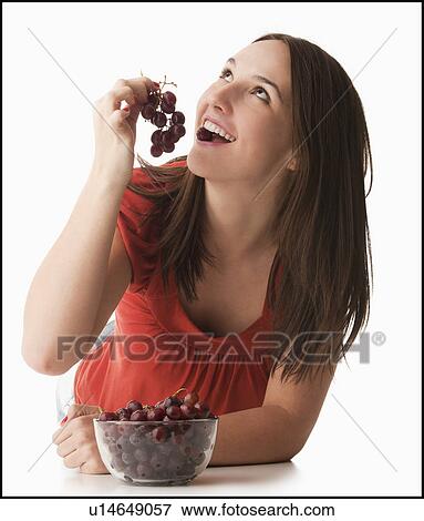 Young woman eating grapes View Large Photo Image Stock Photo - Young woman eating grapes. Fotosearch