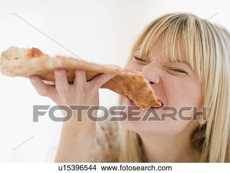 Young woman eating pizza View Large Photo Image Picture - Young woman eating pizza. Fotosearch