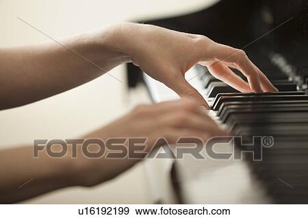 Stock Photo - Young woman hands playing piano. Fotosearch