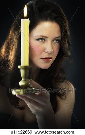 Stock Photo - Young woman holding candle. Fotosearch