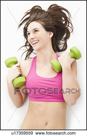 Stock Photo - Young woman holding hand weights. Fotosearch