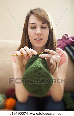 Picture - Young woman knitting woolly hat. Fotosearch