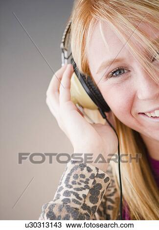 Young woman listening to music View Large Photo Image Stock Image - Young woman listening to music. Fotosearch