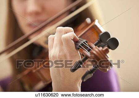 Stock Image - Young woman playing violin. Fotosearch