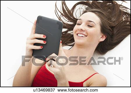 Stock Photo - Young woman using electronic organizer. Fotosearch