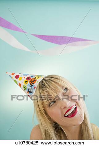 Young woman wearing party hat laughing View Large Photo Image Stock Photography - Young woman wearing party hat laughing. Fotosearch