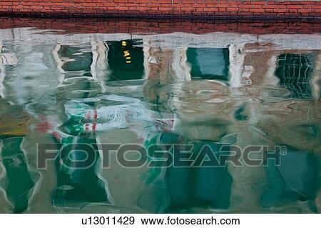 Stock Photo - Abstract reflection patterns of Italian flag and palace buildings, red brick wall in canal water, Venice, Northern Italy. Fotosearch