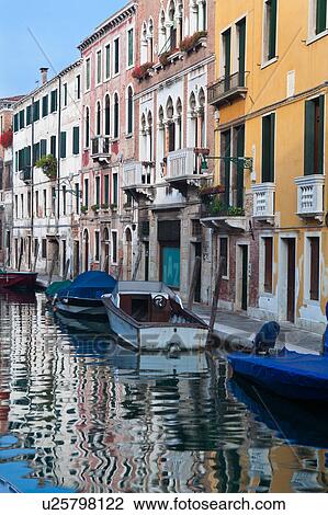 Boats moored alongside canal with reflections of palace buildings in water, sunny autumn morning in Venice, Northern Italy View Large Photo Image Stock Image - Boats moored alongside canal with reflections of palace buildings in water, sunny autumn morning in Venice, Northern Italy. Fotosearch