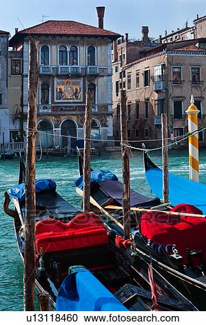 Close up of two gondolas, showing red cushions and seating against background of Grand Canal and ornamented facade of Palazzo Salviati, sunny autumn morning in Venice, Northern Italy View Large Photo Image Stock Image - Close up of two gondolas, showing red cushions and seating against background of Grand Canal and ornamented facade of Palazzo Salviati, sunny autumn morning in Venice, Northern Italy. Fotosearch