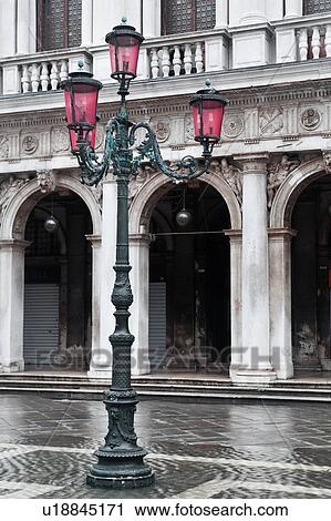 Desaturated image: highly decorated stone balustrade and loggia of Libreria Sansoviana, close up view, traditional ornate wrought iron lampstand with red glass, white markings of Piazzetta under water at Aqua Alta, Venice, Northern Italy View Large Photo Image Stock Image - Desaturated image: highly decorated stone balustrade and loggia of Libreria Sansoviana, close up view, traditional ornate wrought iron lampstand with red glass, white markings of Piazzetta under water at Aqua Alta, Venice, Northern Italy. Fotosearch
