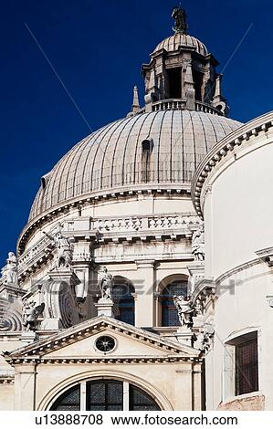 Stock Photo - Detail of church of Santa Maria della Salute: dome, and ornamental stone scroll work and statues below, against deep blue sky, late afternoon in autumn, Venice, Northern Italy. Fotosearch