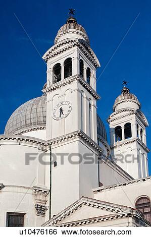Detail of church of Santa Maria della Salute: dome with ornamental stone scroll work and statues below, bell and clock towers, against deep blue sky, late afternoon in autumn, Venice, Northern Italy View Large Photo Image Stock Photograph - Detail of church of Santa Maria della Salute: dome with ornamental stone scroll work and statues below, bell and clock towers, against deep blue sky, late afternoon in autumn, Venice, Northern Italy. Fotosearch