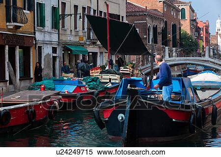 Fruit and vegetable market on colourful blue and red barge with motion blur of vendor and shoppers, with second barge moving in foreground, sunny autumn morning in Venice, Northern Italy View Large Photo Image Stock Photography - Fruit and vegetable market on colourful blue and red barge with motion blur of vendor and shoppers, with second barge moving in foreground, sunny autumn morning in Venice, Northern Italy. Fotosearch