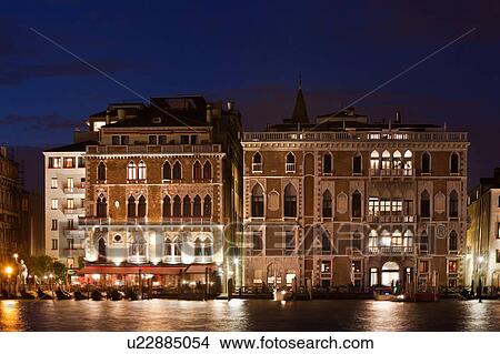 Picture - Night view of Grand Canal with Palazzi lit up against blue starry twilight sky, moored gondolas in front of canal side restaurants, autumn in Venice, Northern Italy. Fotosearch