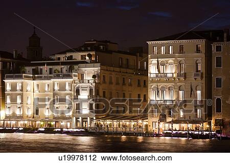 Night view of Grand Canal with Palazzi lit up against blue twilight sky, moored gondolas in front of canal- side restaurants, autumn in Venice, Northern Italy View Large Photo Image Stock Image - Night view of Grand Canal with Palazzi lit up against blue twilight sky, moored gondolas in front of canal- side restaurants, autumn in Venice, Northern Italy. Fotosearch