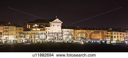 Panorama night view of Grand Canal and San Marco Basin, with church of La Pieta and buildings along Riva della Schiavoni lit up against blue twilight sky, autumn in Venice, Northern Italy View Large Photo Image Picture - Panorama night view of Grand Canal and San Marco Basin, with church of La Pieta and buildings along Riva della Schiavoni lit up against blue twilight sky, autumn in Venice, Northern Italy. Fotosearch