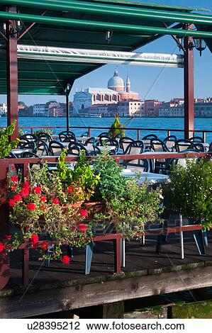 View of Canale della Giudecca, looking towards church of Il Redentore, in late afternoon, with empty outdoor restaurant decorated with boxes of red flowers in foreground, autumn in Venice, Northern Italy View Large Photo Image Stock Image - View of Canale della Giudecca, looking towards church of Il Redentore, in late afternoon, with empty outdoor restaurant decorated with boxes of red flowers in foreground, autumn in Venice, Northern Italy. Fotosearch