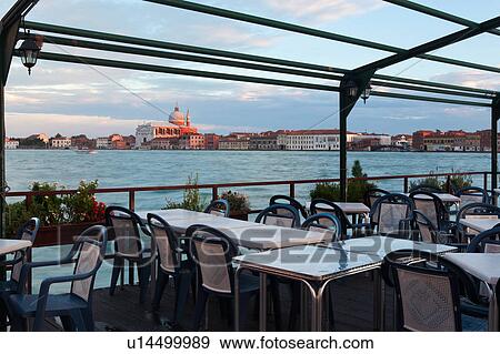 View of Canale della Giudecca, looking towards church of Il Redentore, at sunset, with empty outdoor restaurant in foreground, autumn in Venice, Northern Italy View Large Photo Image Stock Photo - View of Canale della Giudecca, looking towards church of Il Redentore, at sunset, with empty outdoor restaurant in foreground, autumn in Venice, Northern Italy. Fotosearch
