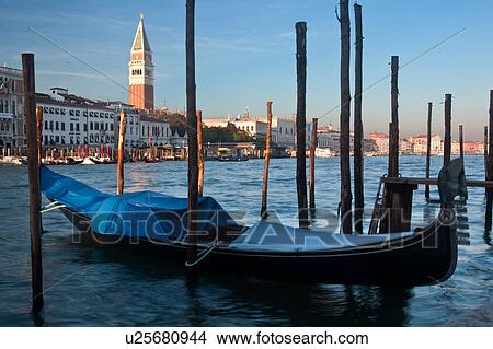 View of Grand Canal, with motion blur of single covered gondola in foreground, Campanile, Doge's Palace and Riva della Schiavoni across canal, in late afternoon sun, autumn in Venice, Northern Italy View Large Photo Image Picture - View of Grand Canal, with motion blur of single covered gondola in foreground, Campanile, Doge's Palace and Riva della Schiavoni across canal, in late afternoon sun, autumn in Venice, Northern Italy. Fotosearch