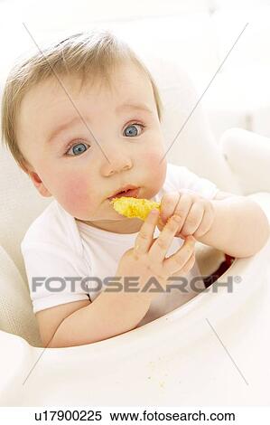 Stock Photography - Baby boy eating a crisp. Fotosearch