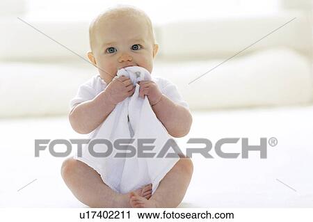 Stock Image - Baby chewing a blanket. Fotosearch