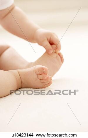 Baby grasping her big toe View Large Photo Image Picture - Baby grasping her big toe. Fotosearch