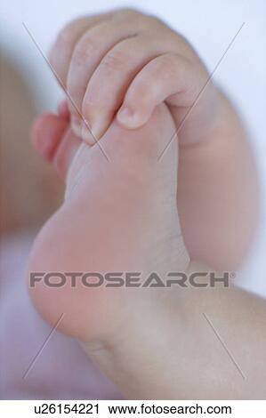 Stock Image - Baby's foot and hand. Fotosearch