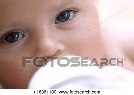 Stock Image - Bottle-feeding baby girl. Fotosearch