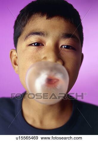 Stock Photo - Boy blowing bubblegum bubble. Fotosearch