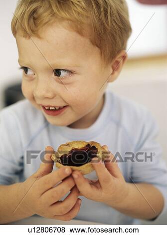 Boy eating a jam tart View Large Photo Image Stock Photo - Boy eating a jam tart. Fotosearch