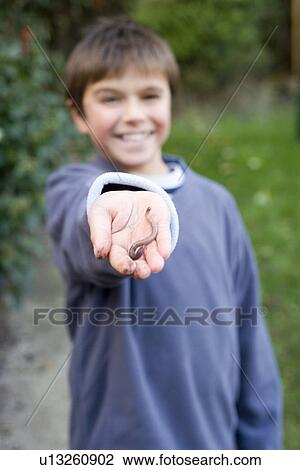 Stock Image - Boy holding an earthworm. Fotosearch
