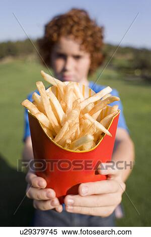 Stock Photography - Boy holding chips. Fotosearch