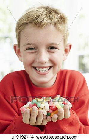 Picture - Boy holding sweets. Fotosearch