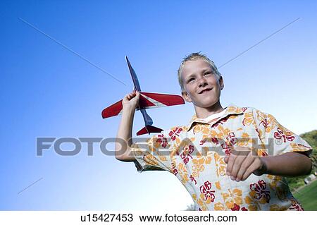 Stock Image - Boy playing with a model aeroplane. Fotosearch