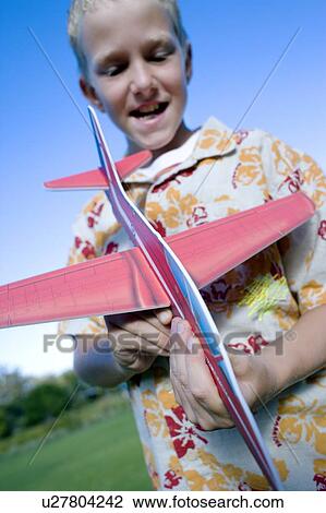 Stock Image - Boy playing with a model aeroplane. Fotosearch