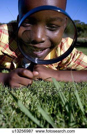 Stock Photo - Boy using a magnifying glass. Fotosearch