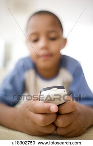 Stock Image - Boy using a mobile phone. Fotosearch