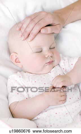 Stock Photograph - Checking a baby's temperature. Fotosearch
