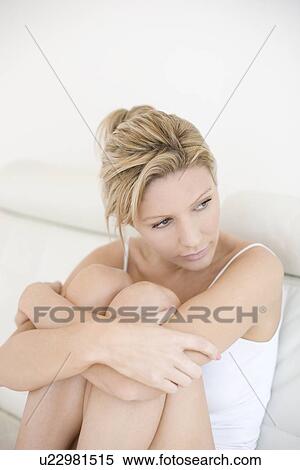 Stock Photography - Depressed young woman holding her knees. Fotosearch
